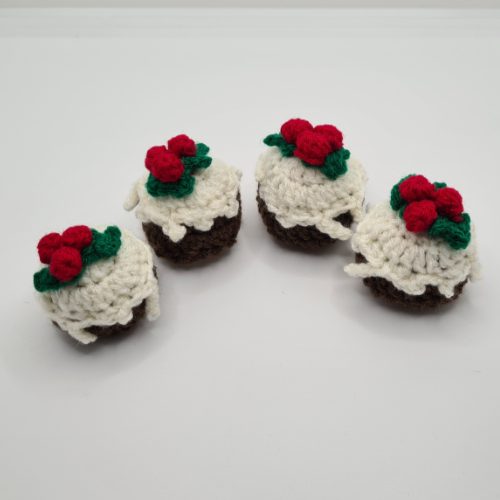 line of four crocheted christmas puddings