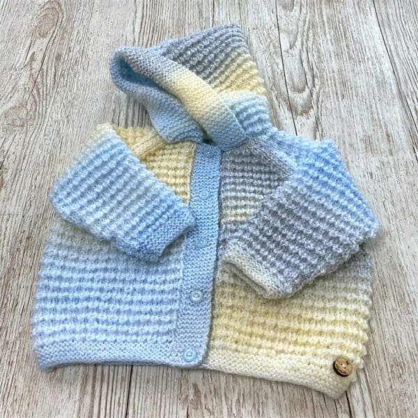 Blue shaded pastel hooded baby jacket to fit 6 - 12 months (boy's button fastening