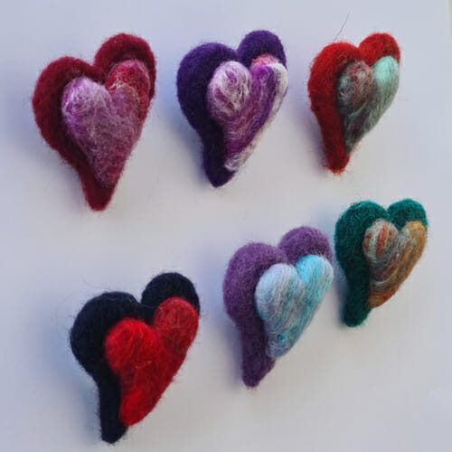 side view of needl felted heart brooches