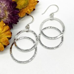 large silver drop earring. made of two large circle hoops overlapped and joined together suspended from ear wires