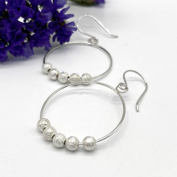 Silver Hoop earrings on ear wires with 5 sparkling silver beads threaded on the hoop