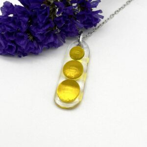 fused glass oblong pendant of clear glass with 3 yellow glass balls fused to base suspended from a silver ring and chain
