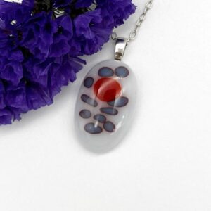 oval shaped fused glass white pendant with blue and red spots on silver chain