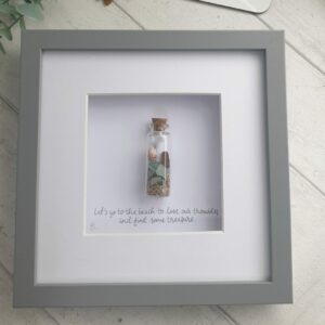 Picture of a glass bottle containing genuine sea glass, shells and sand, along with a message.