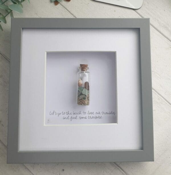 Picture of a glass bottle containing genuine sea glass, shells and sand, along with a message.