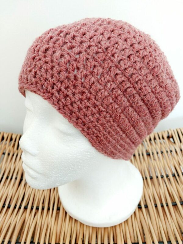 Crochet beanie hat in blush pink aran yarn. Photographed on white mannequin head.