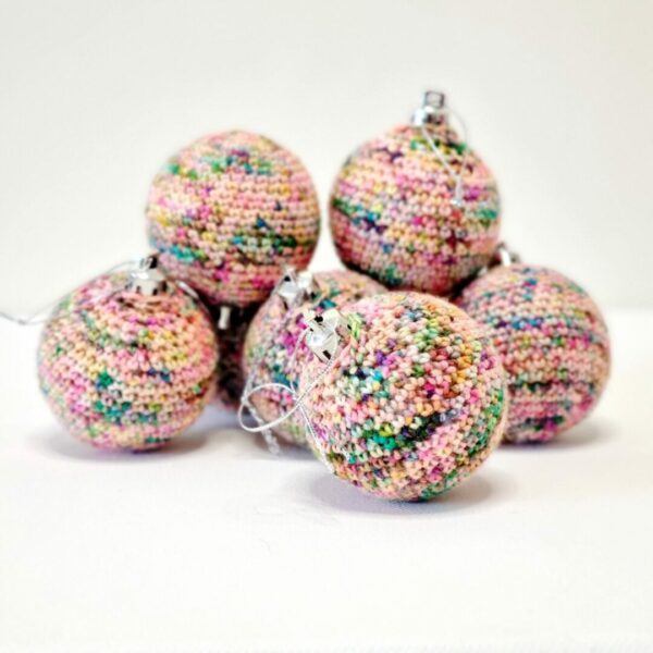 A pile of 6 crocheted rainbow baubles on a white background
