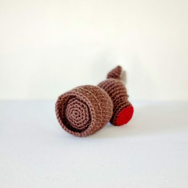 the bottom view of a crochet brown reindeer soft toy with a red nose