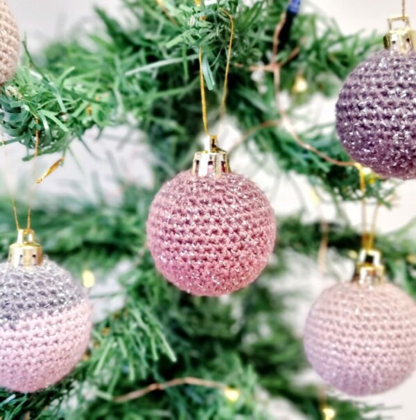 Blush coloured sparkly mini baubles hanging from a Christmas tree