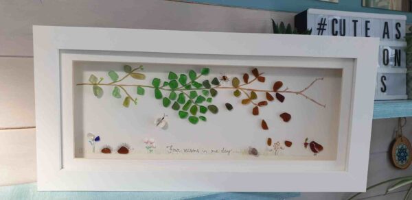A panoramic seaglass picture depicting four seasons.