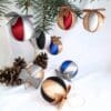 Silver and gold satin Christmas baubles with a glittery bow on top. Paired with colour variations of red, blue and black.