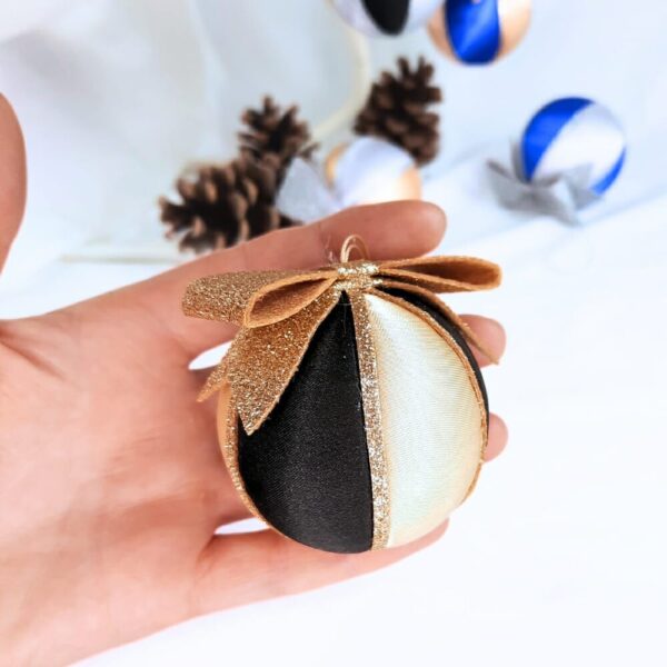 Gold and black satin Christmas bauble with a glittery bow on top.