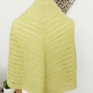 Triangle crochet shawl wrap by Sarah Lou Crafts in a Yellow yarn that is 100% British Wool. Shown on a white dress makers mannequin with a back view.