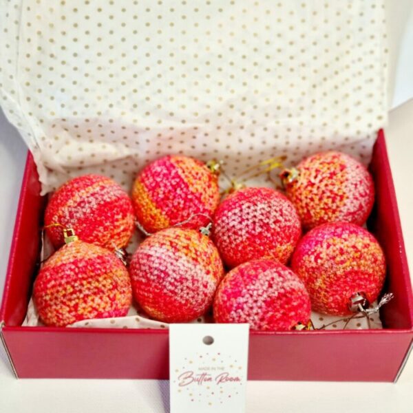 A red postage box full of red and pink baubles