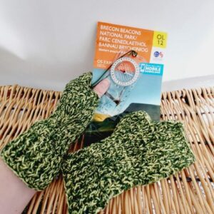 British Wool FIngerless Gloves Mitts in Green and Yellow twist yarn. Shown holding an OS map and compass.