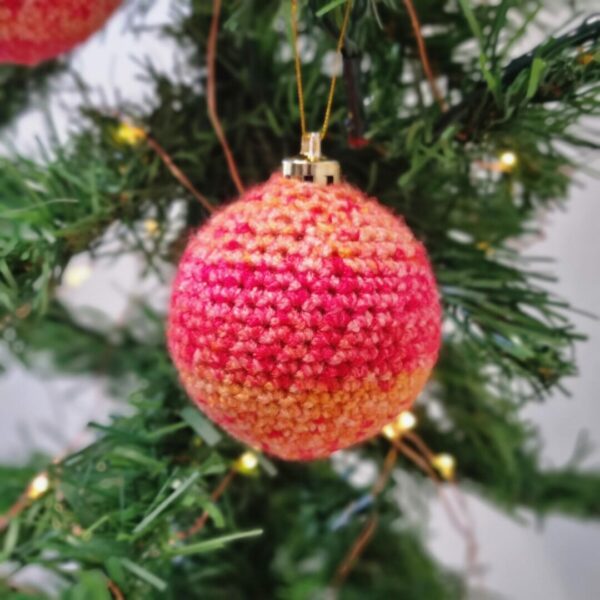 red and orange stripe bauble hanging from a Christmas tree
