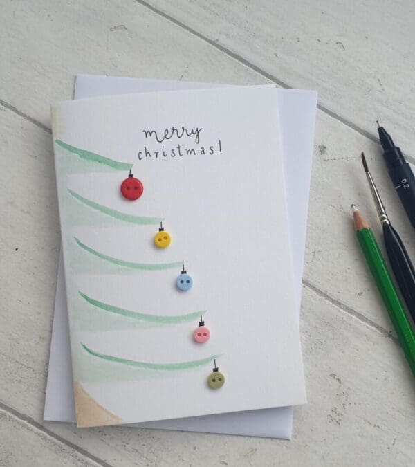Watercolour Christmas cards with added buttons as baubles and the message 'Merry Christmas'