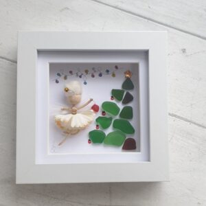 Cute fairy picture made using a Mor Maids miniature fairy with a Christmas tree made of sea glass and a tree made using driftwood and seaglass. Framed in a white box frame 12cm x 12cm.