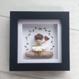 Cute fairy picture made using a Mor Maids miniature fairy sitting on a piece of driftwood with a robin made of seaglass. Framed in a black box frame 12cm x 12cm.