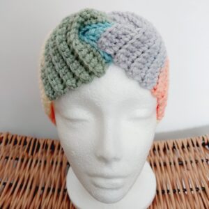 Chunky ribbed crochet ear warmer headband in pastel colours shown on white mannequin head.