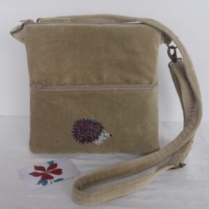 Beige velvet crossbody bag with zip closure, front zipped pocket with appliqued hedgehog