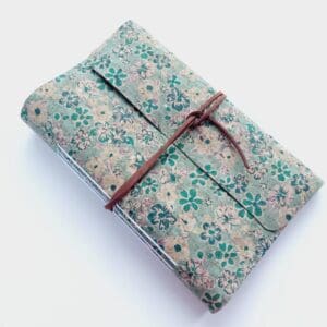 Cork fabric notebook journal with green floral pattern and brown faux suede wrap tie.