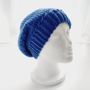 Dark blue crochet slouchy beanie hat with ribbed brim shown on a white mannequin head.
