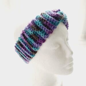 Chunky ribbed crochet ear warmer headband in a purple colourway shown on white mannequin head.