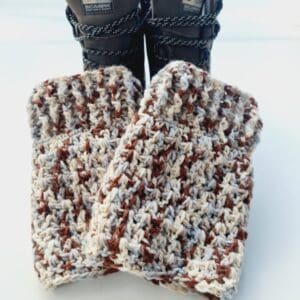Crochet boot cuff ankle warmers, in a variegated yarn of brown, blue and cream shades. Shown in brown hiking boots.