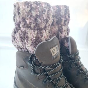 Crochet boot cuff ankle warmers, in a variegated yarn of brown, pink and cream shades. Shown in brown hiking boots.