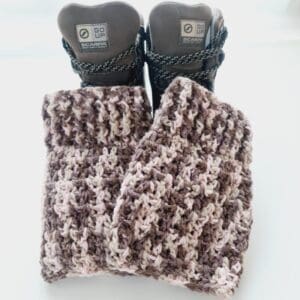 Crochet boot cuff ankle warmers, in a variegated yarn of brown, pink and cream shades. Shown in brown hiking boots.