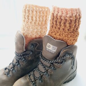 Crochet boot cuff ankle warmers, in a variegated warm chestnut brown colourway. Shown in brown hiking boots.