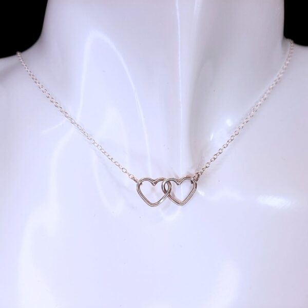 Two silver hearts linked together at the centre of a necklace.