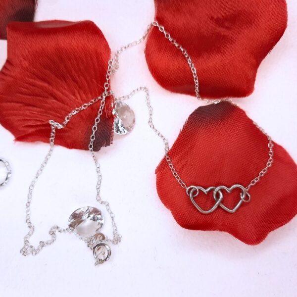 Two silver hearts linked together at the centre of a necklace.
