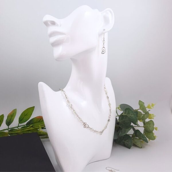 Dangly earrings with round jade gemstone beads and hand crafted silver swirl in a stylised curl shape and matching necklace.