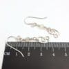 Dangly earrings with round jade gemstone beads and hand crafted silver swirl in a stylised curl shape.