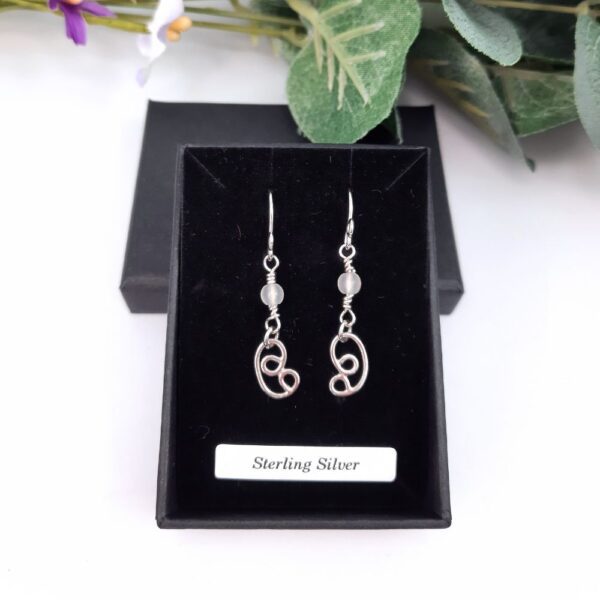 Dangly earrings with round jade gemstone beads and hand crafted silver swirl in a stylised curl shape.