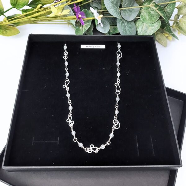 Sterling silver chain link necklace with handcrafted silver swirls, a clasp which blends seamlessly into the design and jade gemstone beads interspersed along the length of the chain.