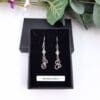 Dangly earrings with round jade gemstone beads and hand crafted silver swirl in a stylised S shape.