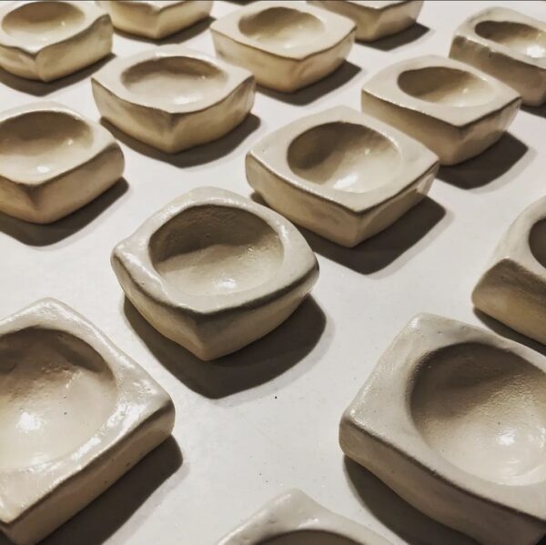 Close up image of a row of hand moulded clay egg cups