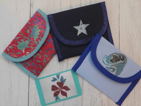 Selection of three coin purses with appliqued designs on their flaps