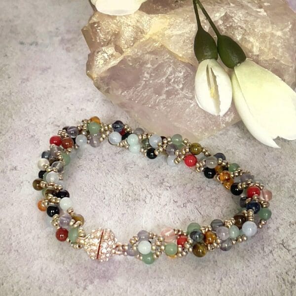 Bracelet in mixed gemstone beads beside rock