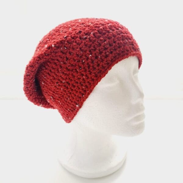Crochet Slouchy Beanie hat in Chilli Red yarn shown at slight angle on white mannequin head.