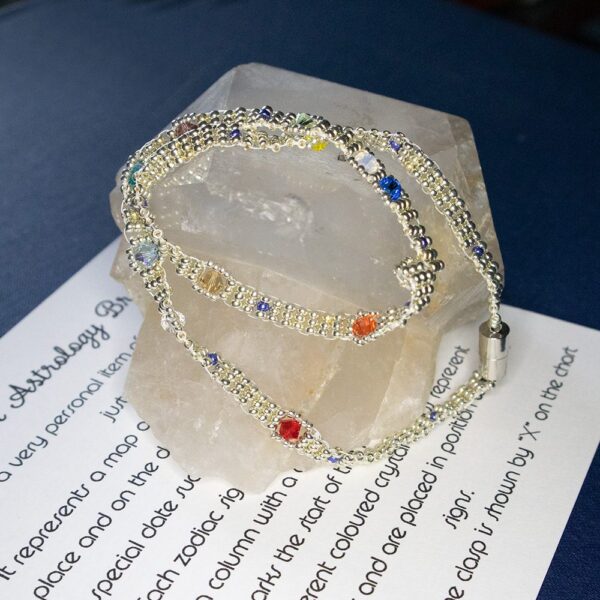 Beadwork wrap bracelet in silver curled on a rock