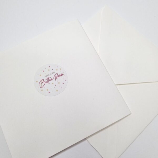 back of square cream greetings card with a round white sticker on and matching envelope.
