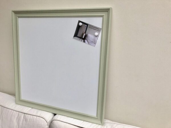 A pale green framed magnetic whiteboard, set against a neutral background.