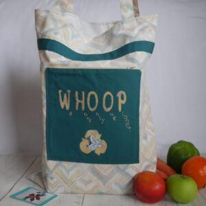 Beige and green tote bag shown with collection of fruit and vegetables.