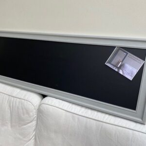 A long magnetic blackboard with ornate frame painted in Farrow & Ball’s Lamp Room Gray