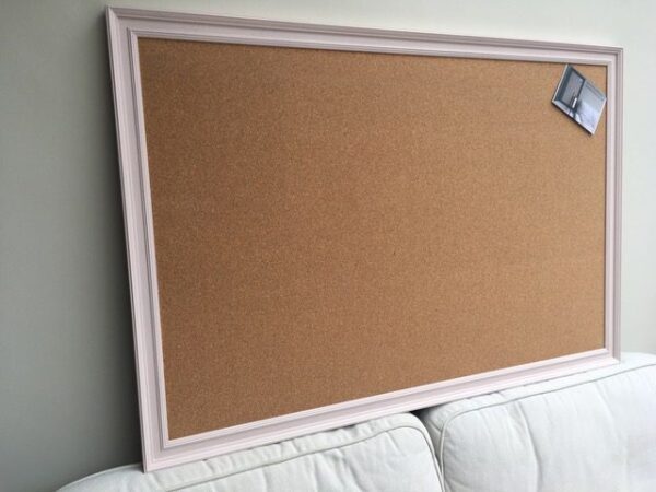 A huge cork pin board with pale pink frame