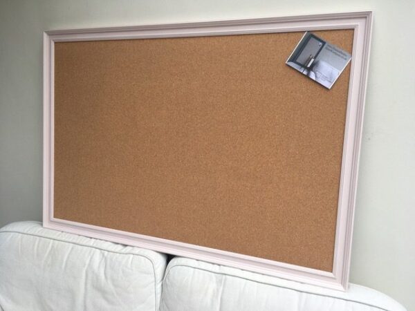 A huge cork pin board with pale pink frame